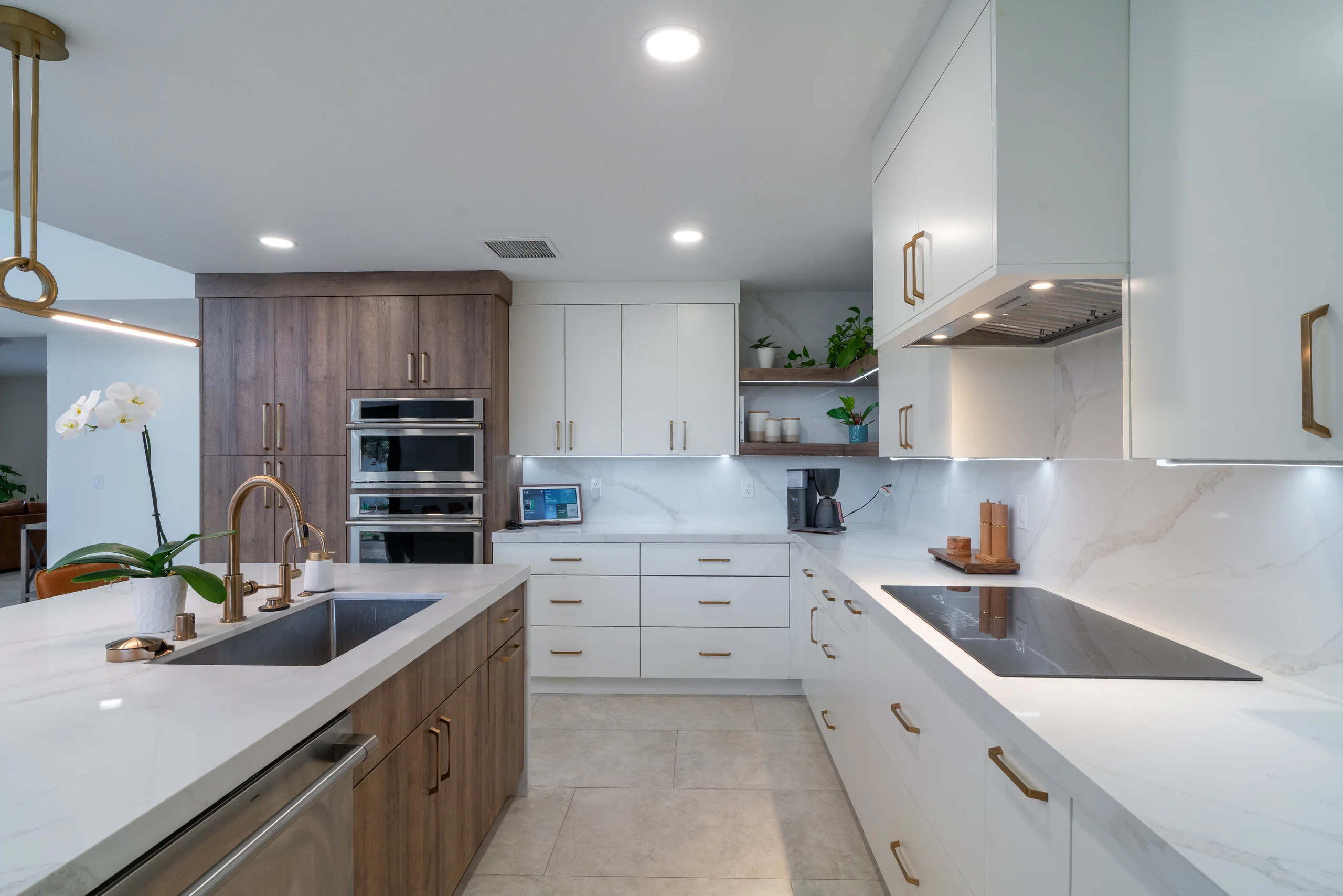 Kitchen cooking area with induction cooktop and ovens