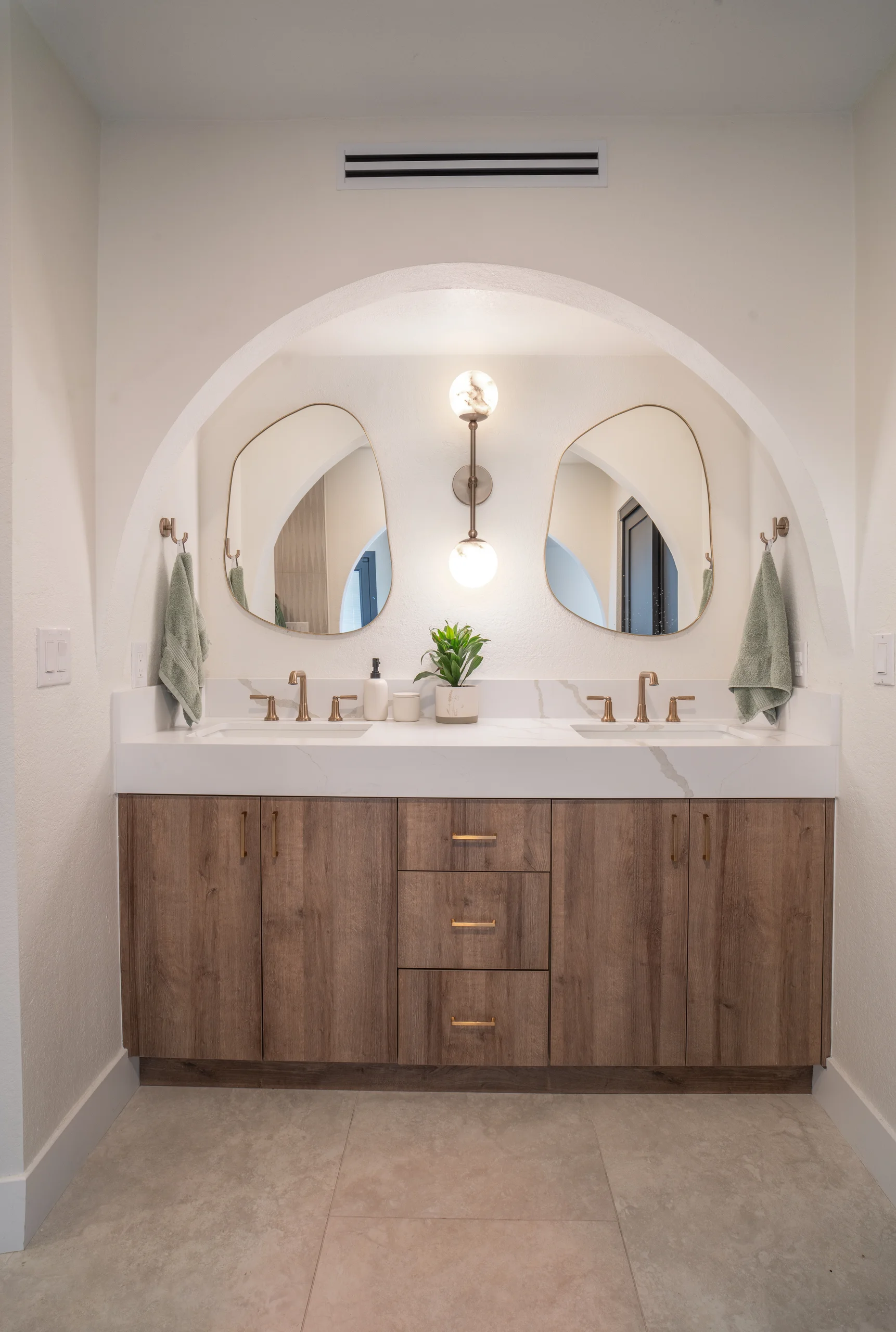 Primary bathroom double vanity in arched alcove