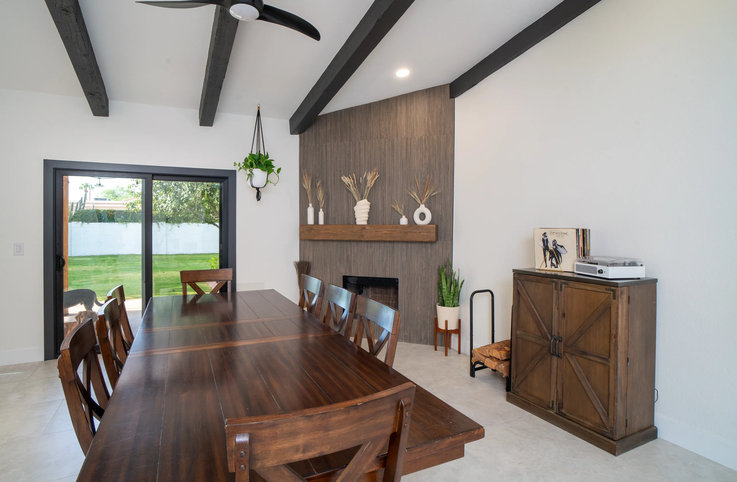 Dining room with linear fireplace and wood accent wall