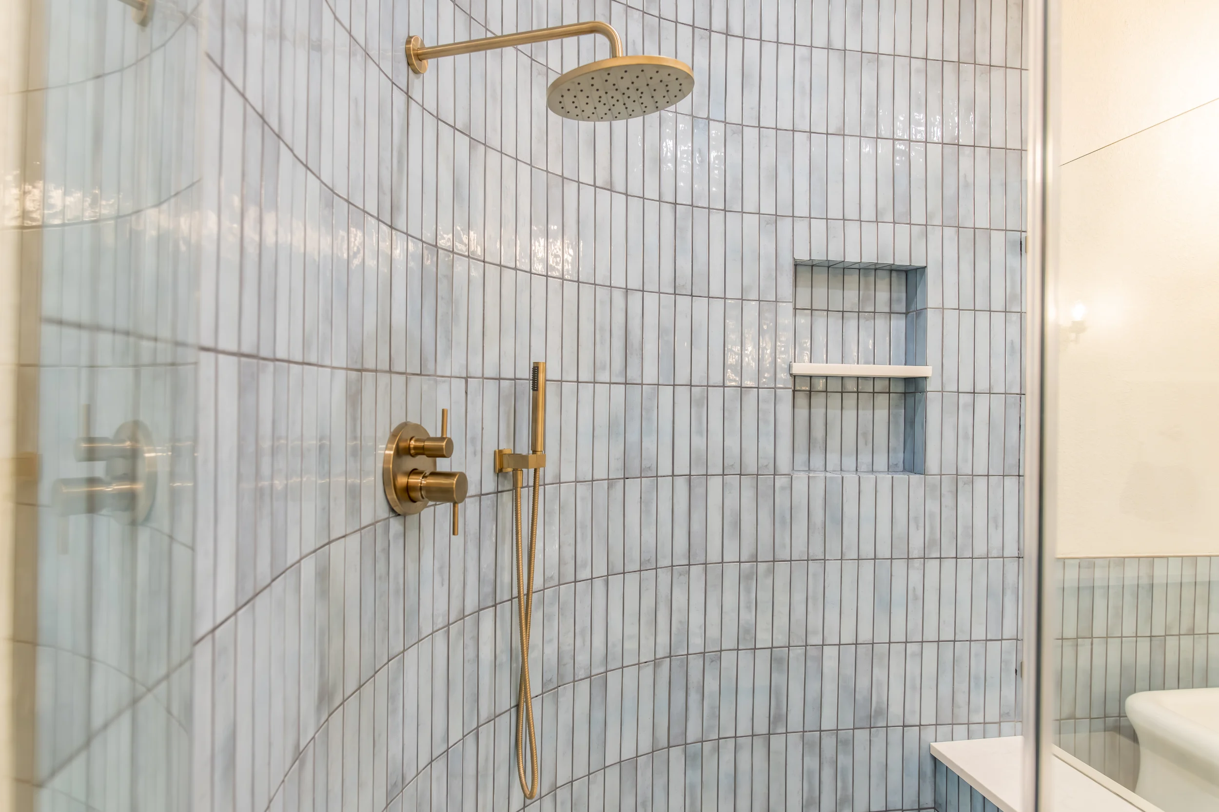 Curved shower wall with blue tile