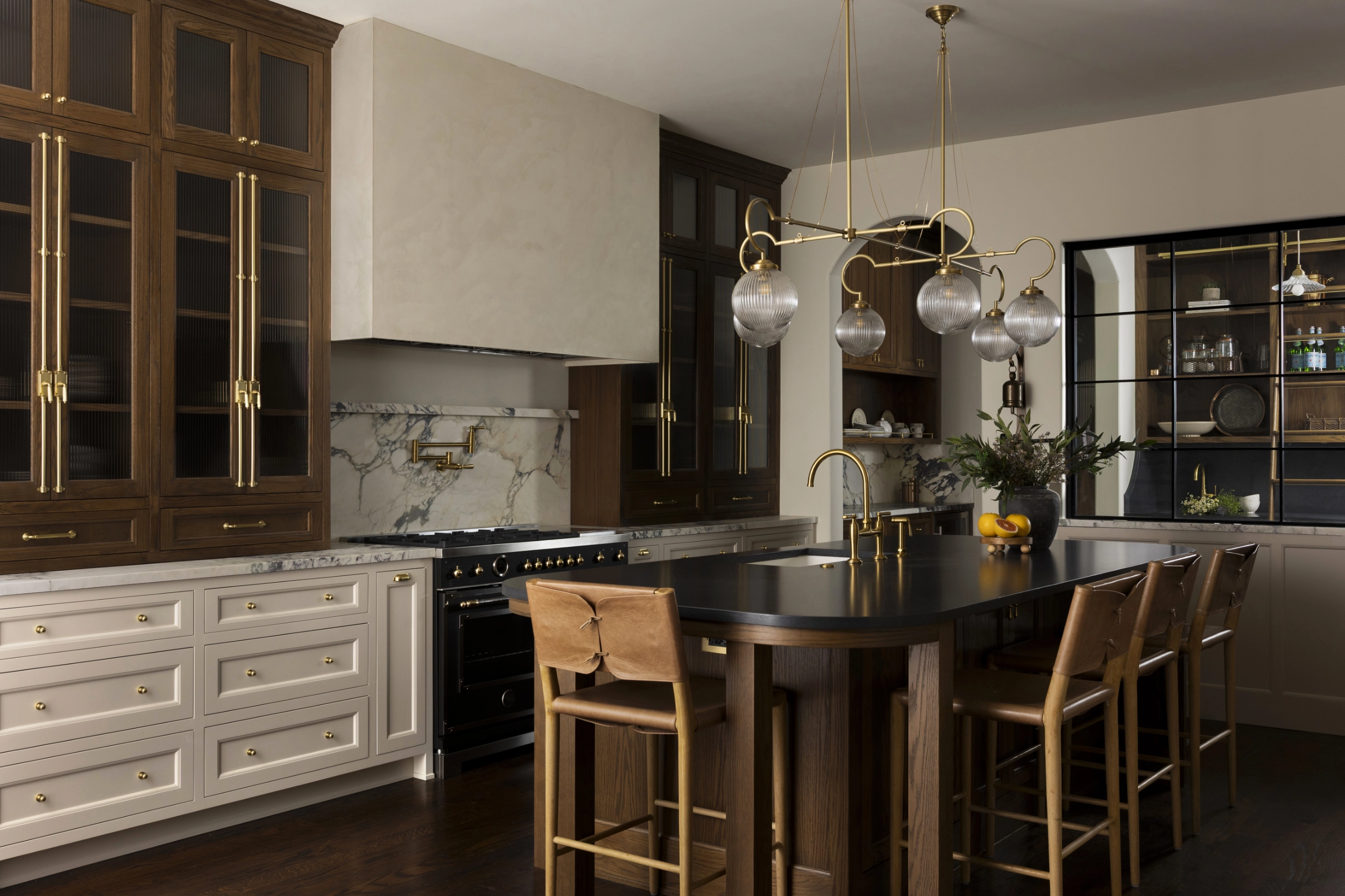 Wide view of the remodeled luxury kitchen with custom cabinetry, lighting and appliances