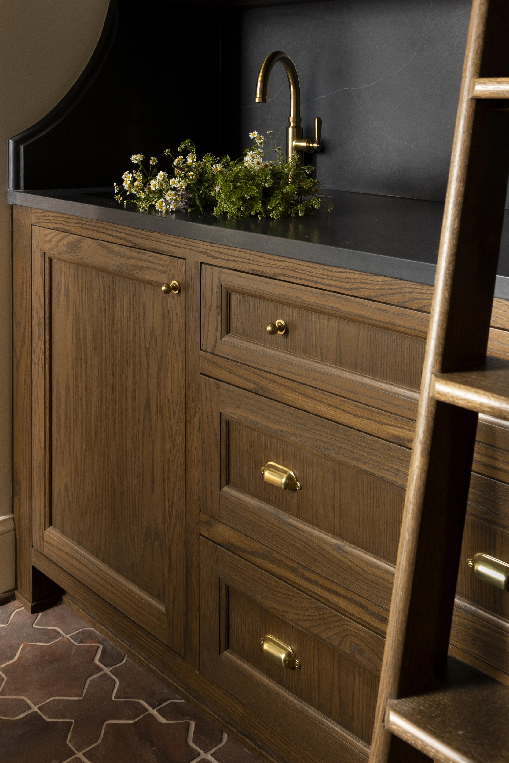 Floor-to-ceiling pantry cabinet with minibar and library ladder